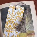 Plantable bookmark with yellow floral pattern and tassel on an open book