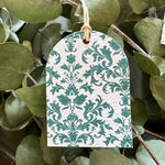 Seed paper green and white patterned tag hanging among green leaves