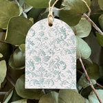 Seed tag with floral pattern hanging among green leaves