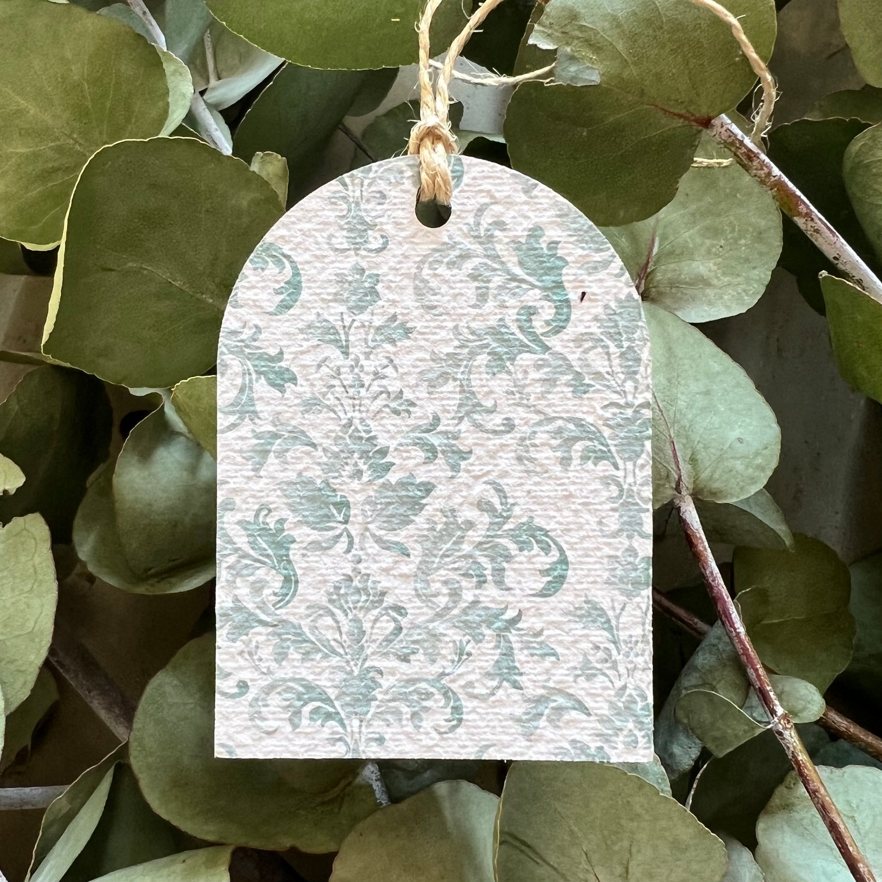 Seed tag with floral pattern hanging among green leaves