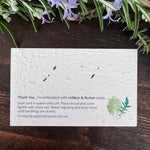 Seed paper card with lettuce and rocket seeds on a wooden surface.